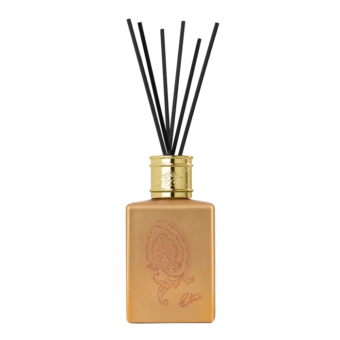 Saffron gold diffuser set in a sleek square glass bottle with a gold cap, featuring a decorative paisley design and black reed sticks for fragrance diffusion.