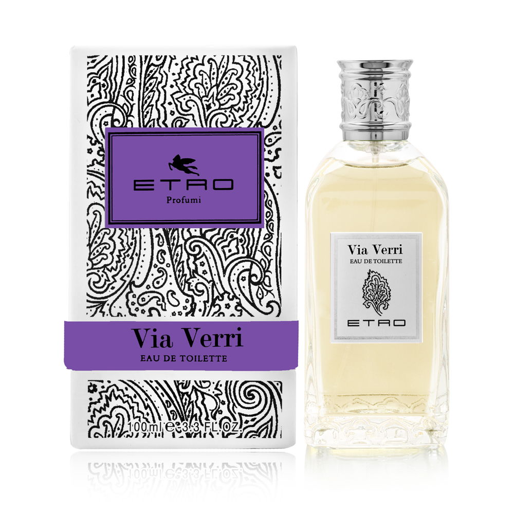 Clear glass bottle with a silver cap, containing light yellow Eau De Toilette, alongside a decorative white box featuring a black paisley pattern and purple accents.