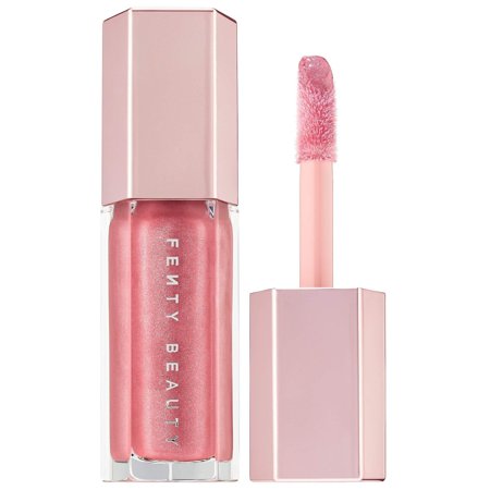 Gloss Bomb Universal Lip Luminizer in FU$$Y, featuring a sleek, clear container with a pink cap and a soft applicator wand, showcasing a shimmering pink lip gloss.