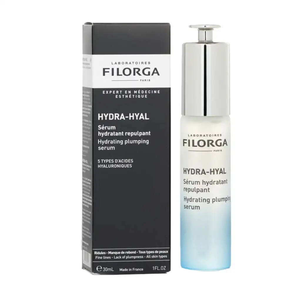 Clear glass bottle with a silver pump, containing a light blue serum, alongside a sleek black box featuring white text and the Filorga logo.