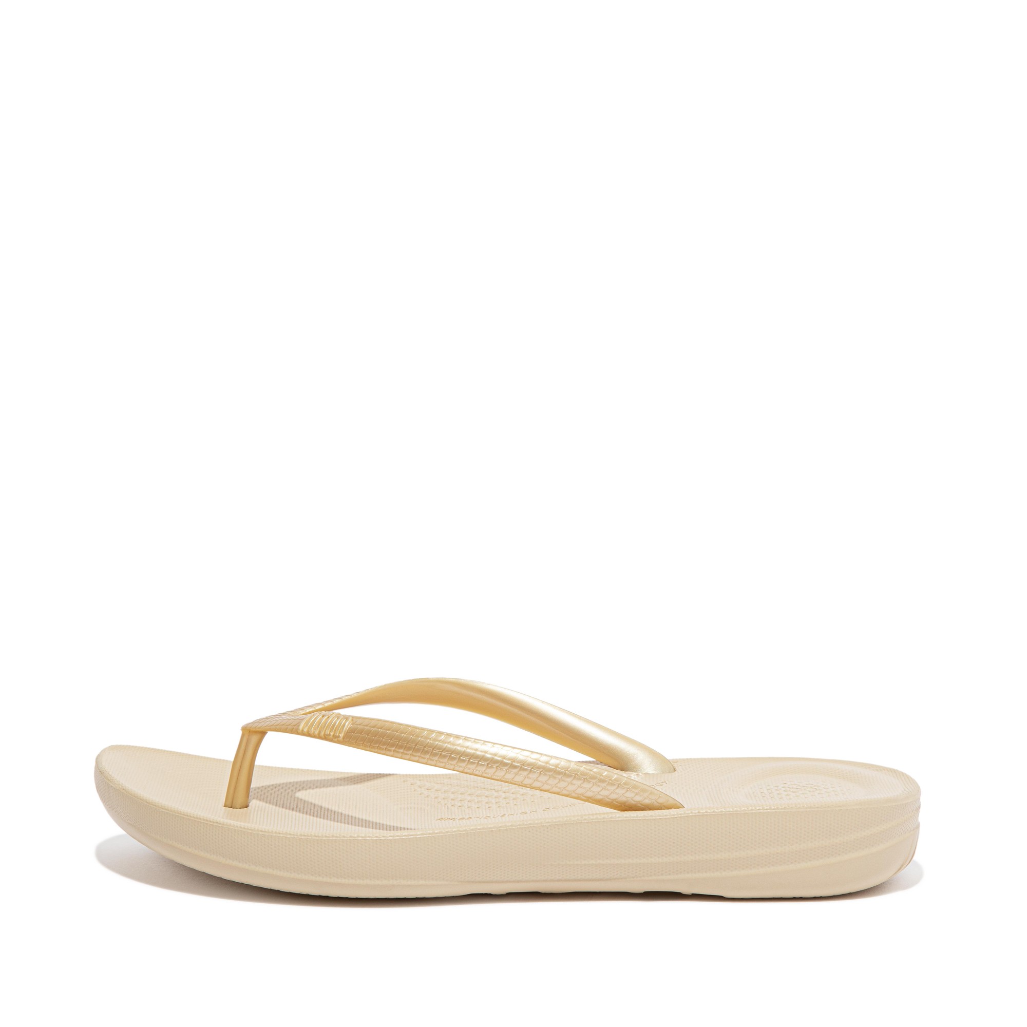 Beige ergonomic flip-flops with a rubber sole and minimalist design, featuring thin, flexible straps for comfort and support.