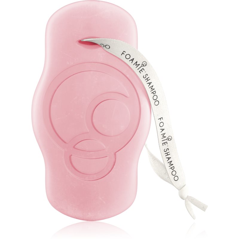 Pink Foamie shampoo bar with a smooth, rounded shape and a playful face design, featuring a white ribbon with "Foamie Shampoo" printed on it.