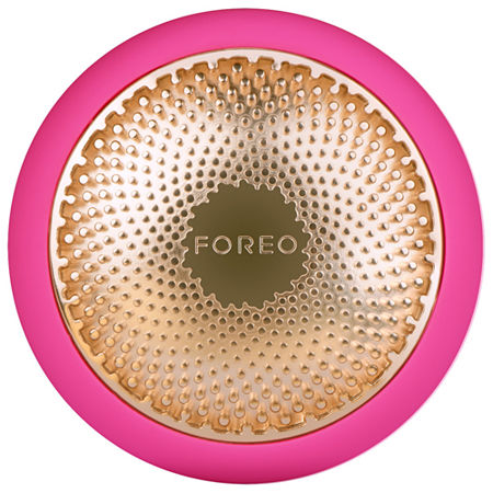 Round, vibrant pink facial device with a textured gold center featuring the "FOREO" logo, designed for skincare treatments.