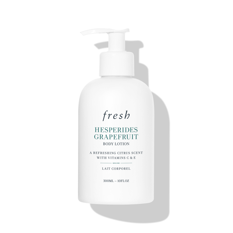 White plastic bottle with a pump dispenser, labeled "Fresh Hesperides Grapefruit Body Lotion," featuring a refreshing citrus scent and highlighting vitamins C and E.