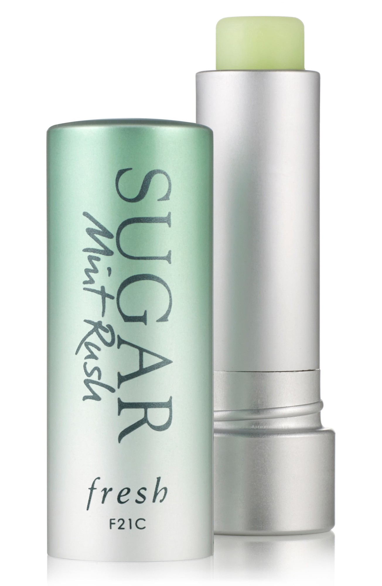 A silver tube with a mint green label reading "SUGAR Mint Rush" and "fresh," containing a light green lip treatment stick.