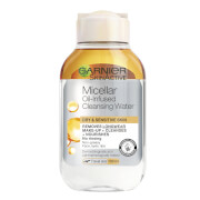 Clear plastic bottle of Garnier Micellar Cleansing Water with a yellow cap, featuring a label that highlights its oil-infused formula for removing makeup and cleansing sensitive skin.