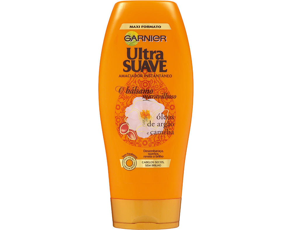 Orange plastic bottle of Garnier Ultra Suave conditioner, 400ml, featuring a floral design and text highlighting its moisturizing properties with argan and camellia oils.
