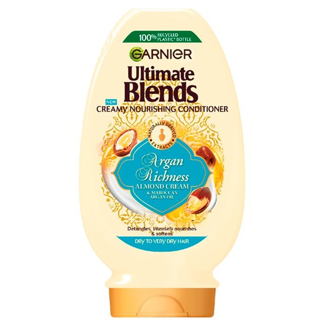 Creamy, pale yellow bottle of Garnier Ultimate Blends Argan Richness Conditioner, featuring a decorative label with almonds and argan oil, designed for dry to very dry hair.