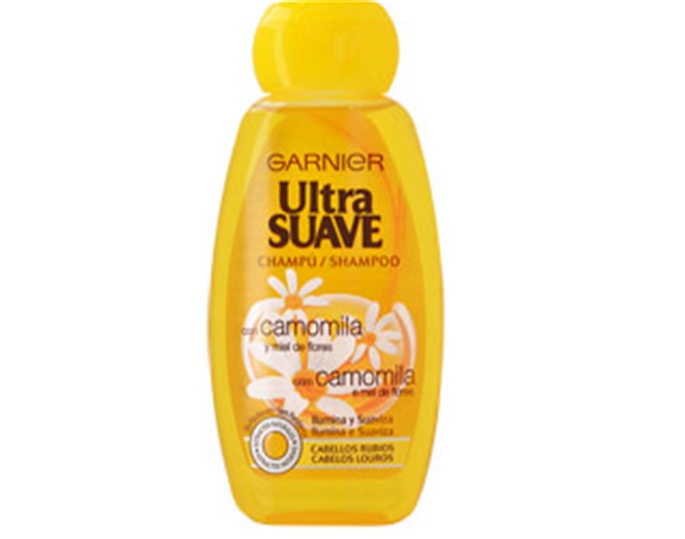 Yellow plastic bottle of Garnier Ultra Suave shampoo for blonde hair, featuring chamomile and honey, with a flip-top cap and a label displaying product details in bold text.