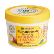 Yellow circular container with a white base, labeled "Garnier Ultimate Blends Nourishing Hair Food Banana," featuring a banana graphic and a lid with a green logo, 390ml size.