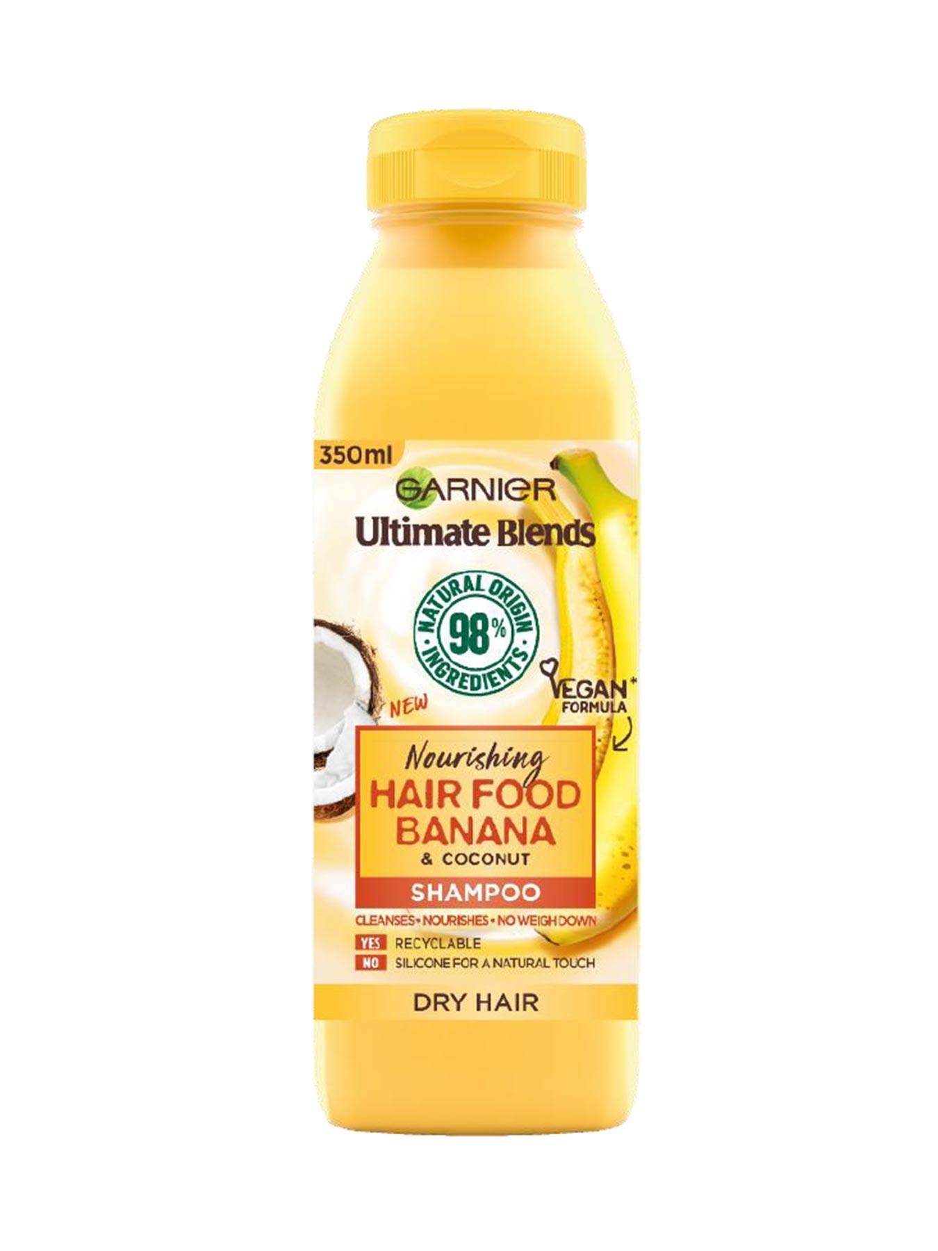 Yellow bottle of Garnier Ultimate Blends Hair Food Banana & Coconut Shampoo, 350ml, featuring a vegan formula, with a label highlighting nourishing properties for dry hair.