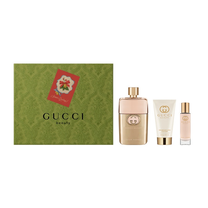 Gucci Guilty Eau De Parfum Spray 90ml set includes a large perfume bottle, a cream, and a travel-sized spray, all in elegant packaging with a green and gold design.