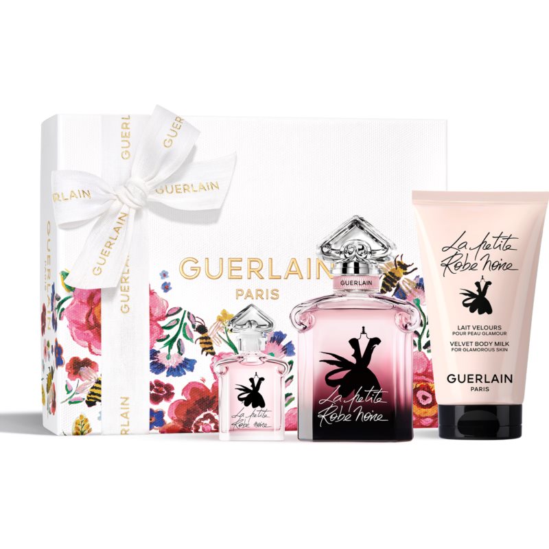 Guerlain La Petite Robe Noire gift set featuring a 50ml pink EDP bottle, a 5ml mini EDP, and a 75ml body lotion, all presented in a floral-printed gift box with a white ribbon.