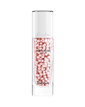 Clear glass bottle containing pink pearl-like beads, labeled "Meteorites Base" by Guerlain, with a sleek silver cap, part of the Spring Glow Collection.