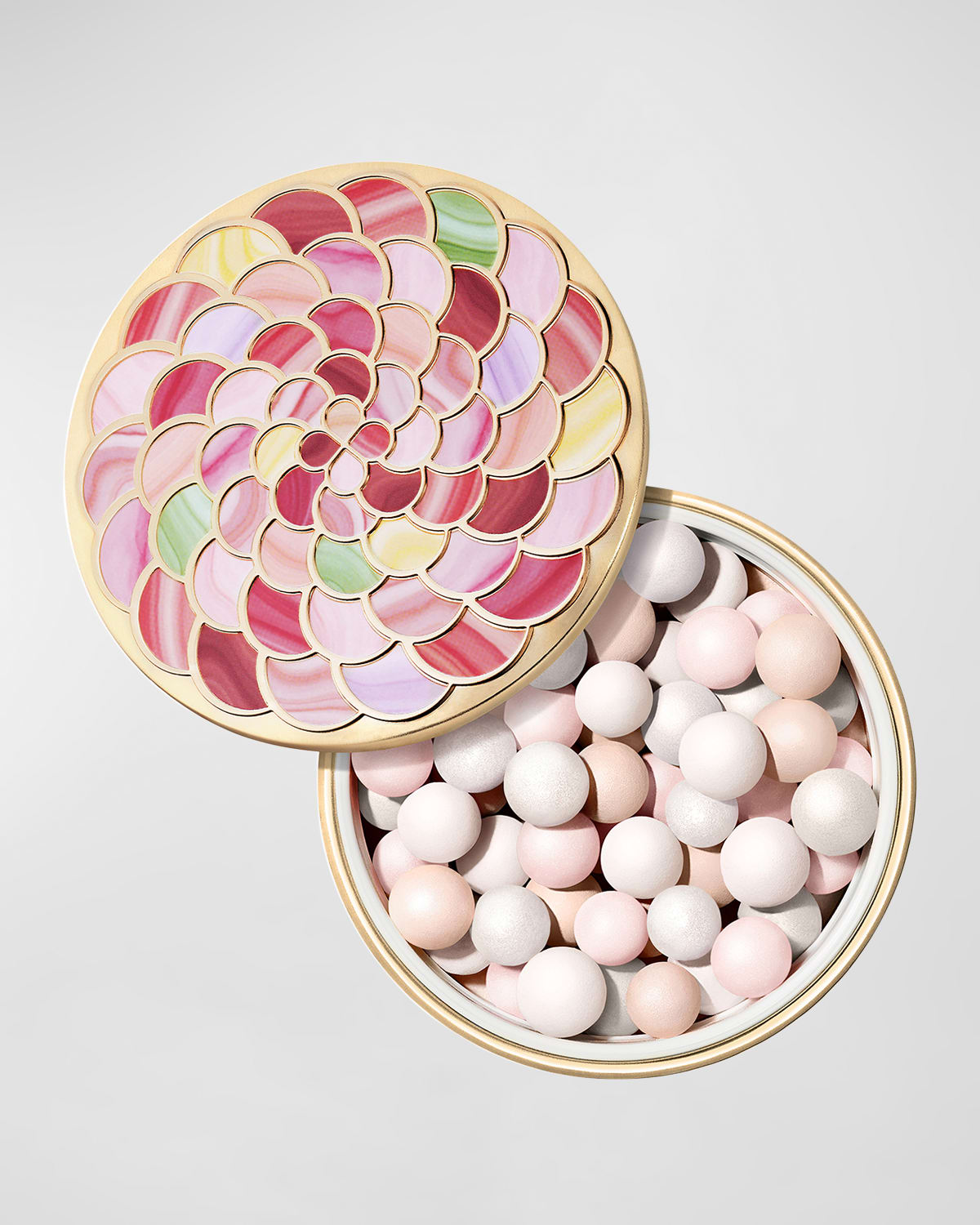 Guerlain Meteorites Light-revealing Pearls of Powder in a round, gold tin with a colorful floral design, containing various pastel-colored and shimmering pearls.