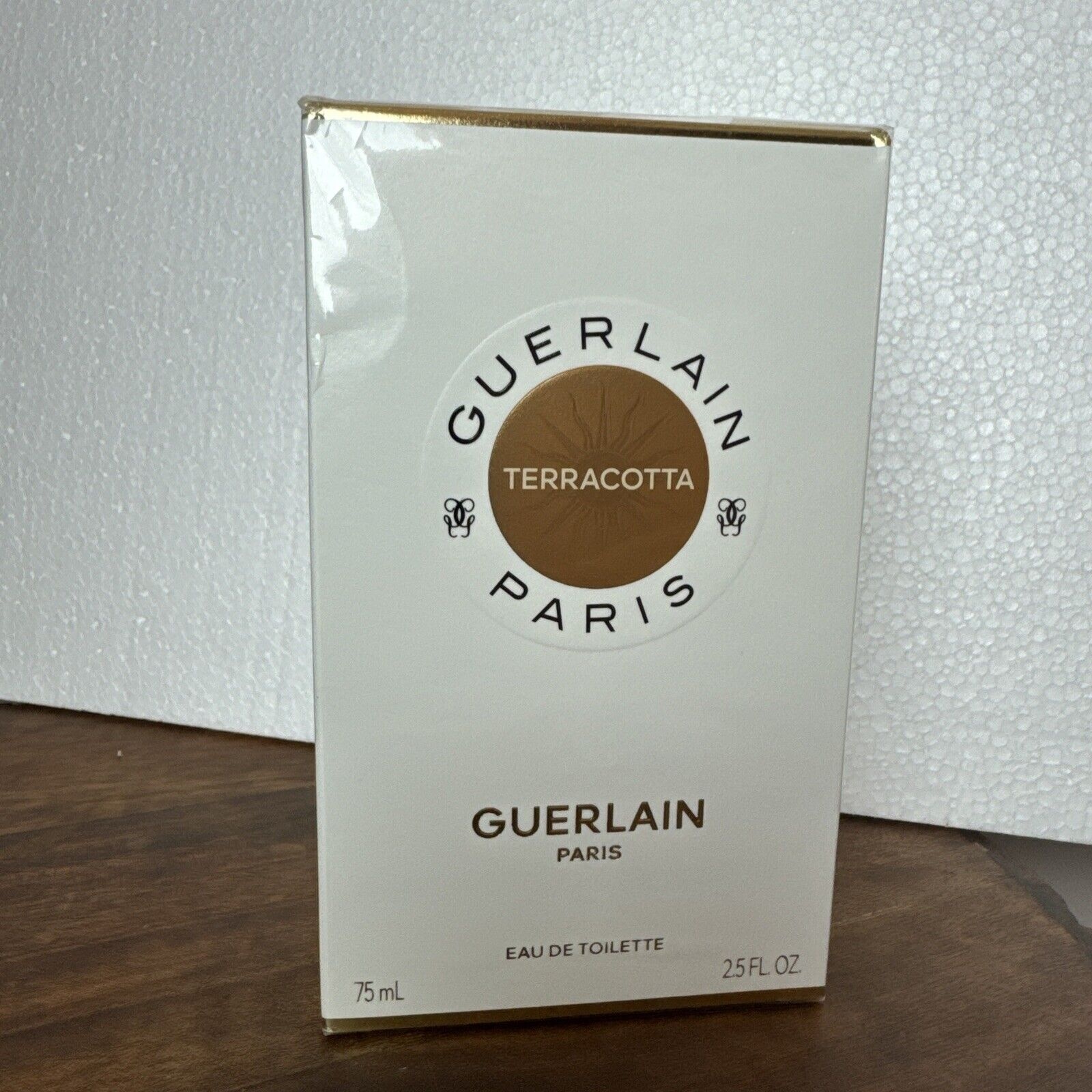 White rectangular box with gold accents, featuring the Guerlain logo, "Terracotta" emblem, and product details; contains 75ml of Eau De Toilette for women.