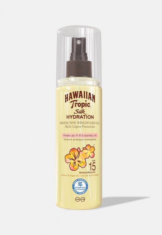 A clear spray bottle with a yellow liquid, featuring a tropical flower design, labeled "Hawaiian Tropic Silk Hydration Dry Oil Mist SPF 15," with a pump spray top.