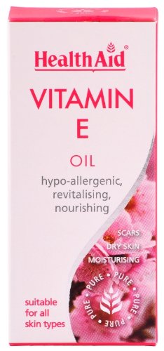Health Aid Vitamin E Oil in a pink and white box, highlighting "100% Pure" and features like hypoallergenic, revitalizing, and nourishing for all skin types.