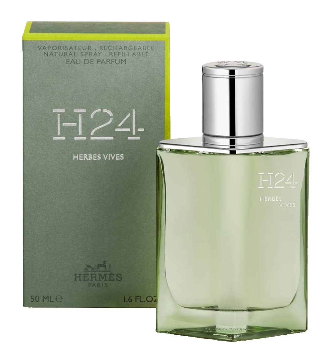 Clear glass bottle with a silver cap, featuring a greenish hue, alongside a green box labeled "H24 Herbes Vives" in white text, both from Hermès.