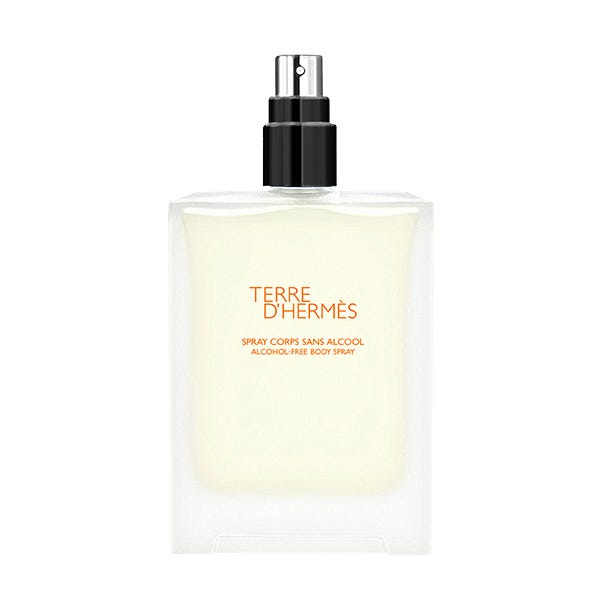 Clear glass bottle with a black spray nozzle, featuring an orange label that reads "TERRE D'HERMÈS" and "SPRAY CORPS SANS ALCOOL," containing 100ml of body spray.