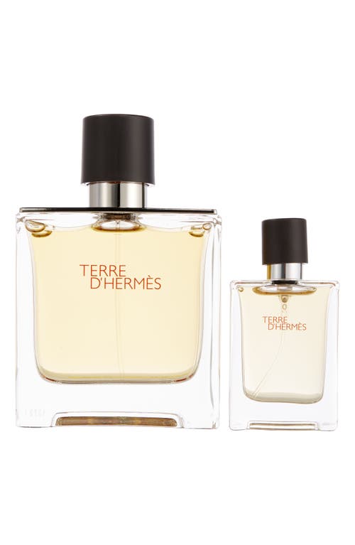 Clear glass perfume bottles with black caps, featuring the label "TERRE D'HERMÈS" in red, one 75ml and a miniature 12.5ml, showcasing a light amber liquid inside.