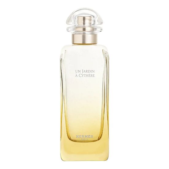 Clear glass bottle with a rounded cap, featuring a gradient from transparent to soft yellow, labeled "Un Jardin À Cythère" and "Hermès" in elegant font.