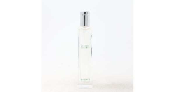 Clear glass bottle of "Hermes Un Jardin Sur Le Toit" EDT, 15ml, featuring a sleek design, silver cap, and minimalist white label with green text.