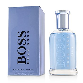 Clear glass bottle with a blue liquid, featuring a sleek design and a silver cap, next to a light blue box labeled "BOSS HUGO BOSS BOTTLED TONIC" in bold black letters.