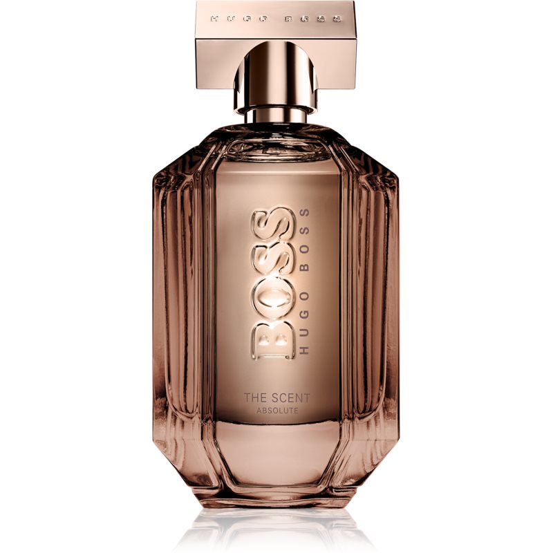Clear glass bottle with a rose gold cap, featuring a faceted design and embossed "BOSS HUGO BOSS" logo, containing a light amber fragrance.