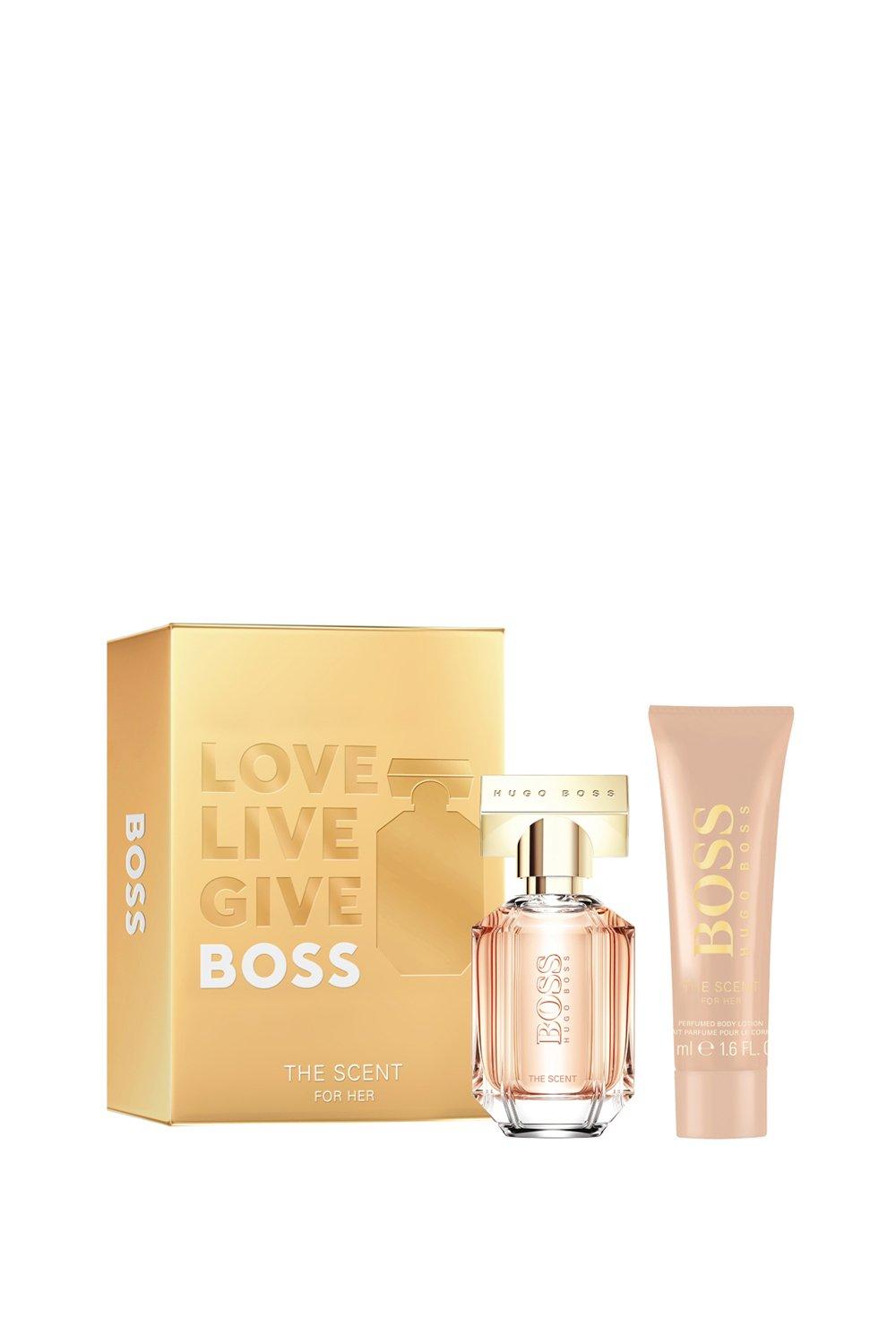 Hugo Boss the Scent for Women gift set featuring a 30 ml EDP in a clear glass bottle with a gold cap and a 50 ml body lotion in a soft pink tube, packaged in a gold box with embossed text.