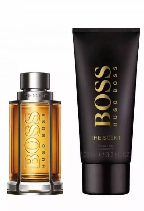 Gift box featuring Hugo Boss The Scent Eau de Toilette in a clear glass bottle with a gold cap and a black tube of shower gel, both prominently displaying the "BOSS" logo.