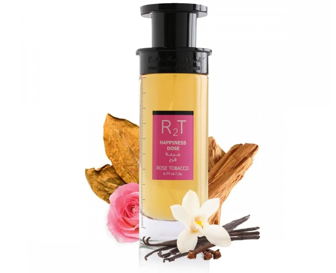 R2T Rose Tobacco 75ml spray bottle with a sleek black cap, featuring a pink label, surrounded by rose petals, vanilla pods, and dried tobacco leaves.