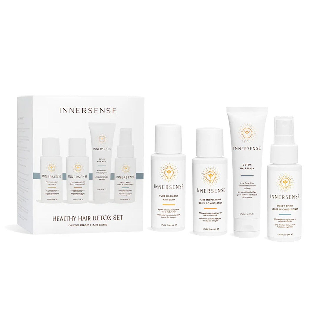 White box with gold sun logo contains five hair care products: three 59ml bottles and one 295ml tube, all featuring clean, minimalist designs and labeled for detoxifying hair health.