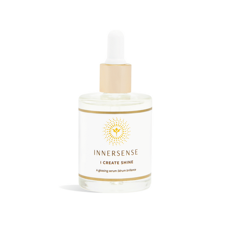Clear glass bottle with a white label and gold accents, featuring a dropper lid, containing 50ml of glossy hair serum labeled "I Create Shine" by Innersense.