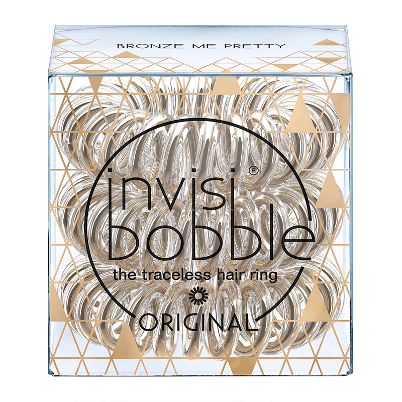 Clear box containing multiple bronze hair rings with a geometric gold design, labeled "invisibobble Original" and "Bronze Me Pretty," highlighting their traceless feature.