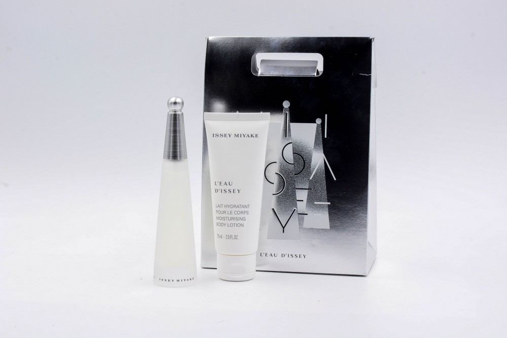 Clear glass perfume bottle with a silver cap, accompanied by a white body lotion tube, all presented in a sleek silver gift box featuring the Issey Miyake logo.