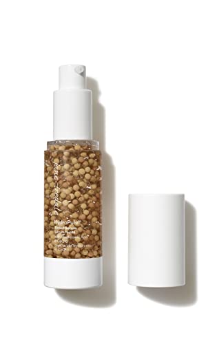 HydroPure Tinted Serum in a clear bottle with a white pump, featuring medium-dark shade 5, contains small golden beads for a hydrating finish.