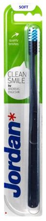 Jordan Clean Smile Soft Toothbrush in black with a blue and white bristle head, packaged in a green and white blister pack featuring the Jordan logo prominently.