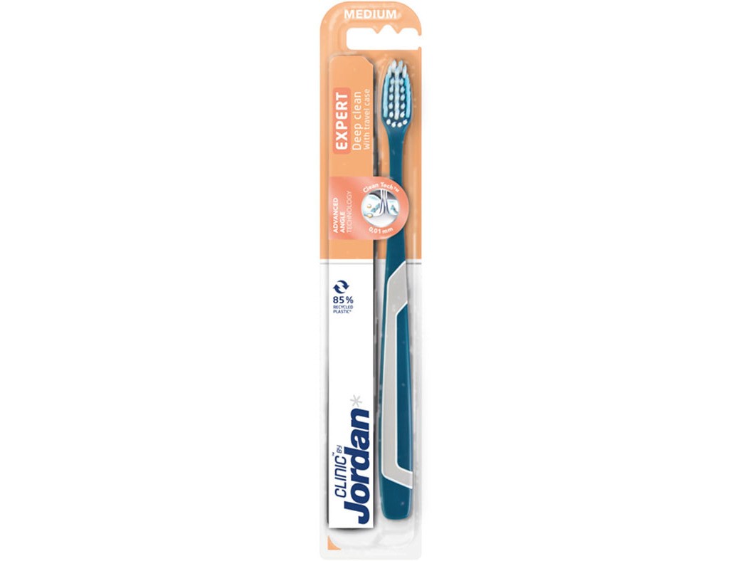 Jordan Clinic Expert toothbrush in medium firmness, featuring a teal handle with a white grip, and a head with soft bristles designed for deep cleaning, packaged in a clear plastic blister.