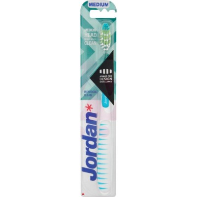 A medium-sized Jordan toothbrush with a white handle featuring blue stripes, a green and white bristle head, and packaging displaying a modern geometric design.