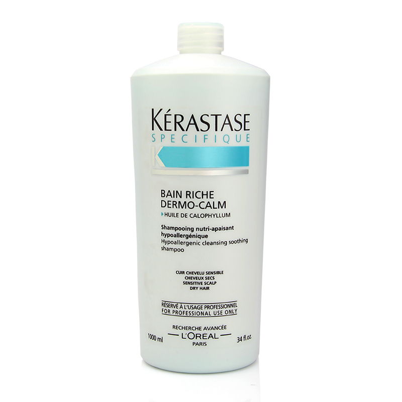 Light blue bottle of Kérastase Specifique Bain Riche Dermo-Calm shampoo, 1000ml, featuring a sleek design with white text and a flip-top cap, designed for sensitive scalp and dry hair.