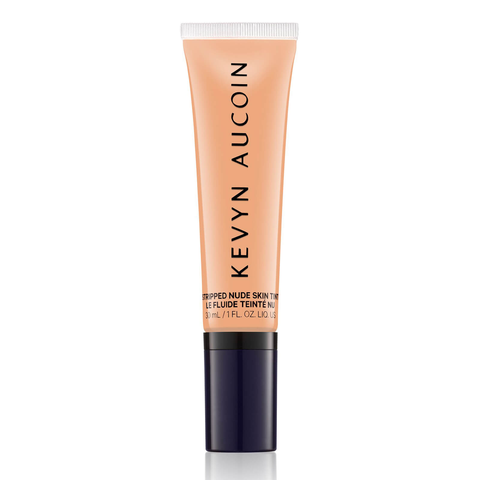 Light peach-colored tube of Kevyn Aucoin Stripped Nude Skin Tint with a dark blue cap, featuring sleek branding in bold black letters.
