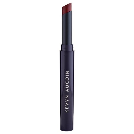Unforgettable Matte Lipstick by Kevyn Aucoin in a sleek, dark purple tube with a twist-up applicator, featuring a rich, deep red shade.