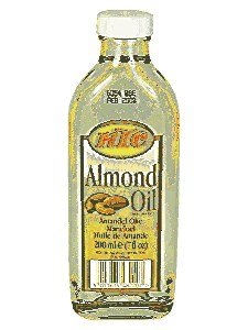 Clear glass bottle of KTC Almond Oil, 200ml, featuring a yellow and orange label with almonds, and a twist-off cap, showcasing its light golden oil inside.