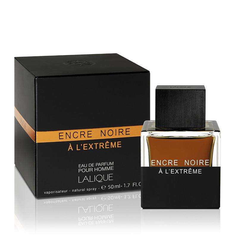 Black rectangular box with orange accents labeled "Encre Noire à L'Extrême" and a glass bottle featuring a square black cap, showcasing a golden-brown fragrance inside.
