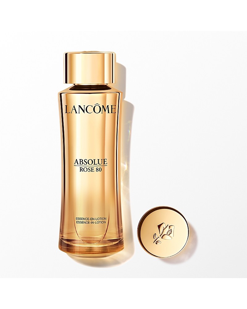 Lancôme Absolue Rose 80 Essence-in-lotion in a sleek, golden bottle with a round cap, featuring elegant branding and a floral emblem, designed for hydration.