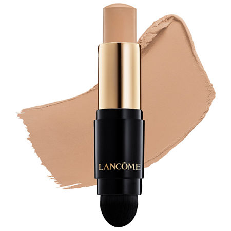 Lancôme Teint Idole Ultra Wear Foundation Stick in a sleek black and gold tube, featuring a creamy beige stick and a built-in blending sponge at the base.