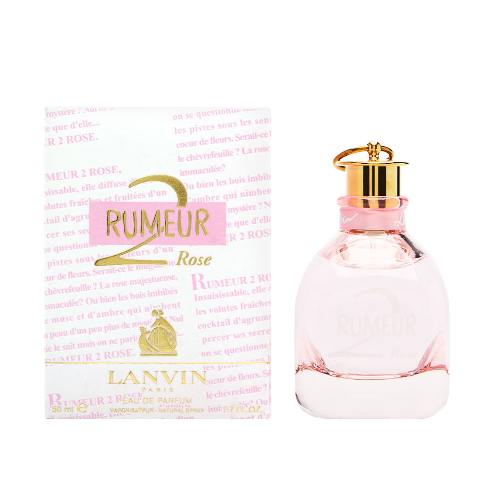 Clear glass bottle with a pink tint, gold cap, and elegant curves, alongside a pink and white box featuring gold text and floral motifs, labeled "Rumeur 2 Rose Eau De Parfum 50ml."
