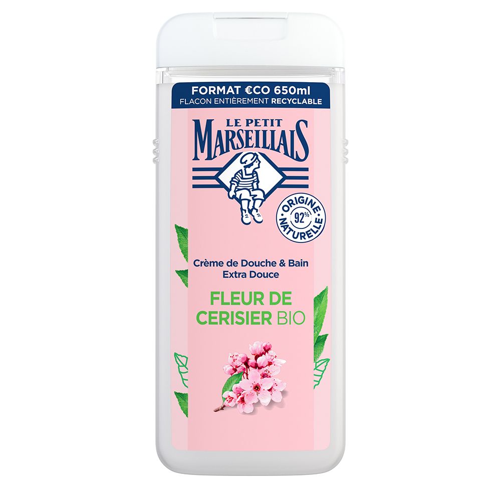 A 650 ml recyclable bottle of Le Petit Marseillais Shower and Bath Cream, featuring a soft pink label with cherry blossom graphics and text highlighting 92% natural ingredients.