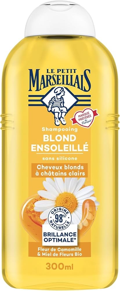 Yellow bottle of "Le Petit Marseillais Shampooing Blond Ensoleillé," featuring a chamomile flower and honey graphic, with a 300ml capacity and a silicone-free formula.